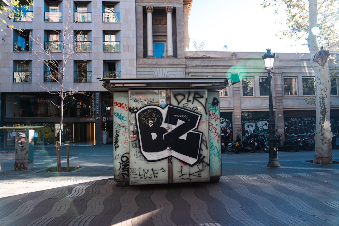 Graffiti-covered newsstand on a sunny city street