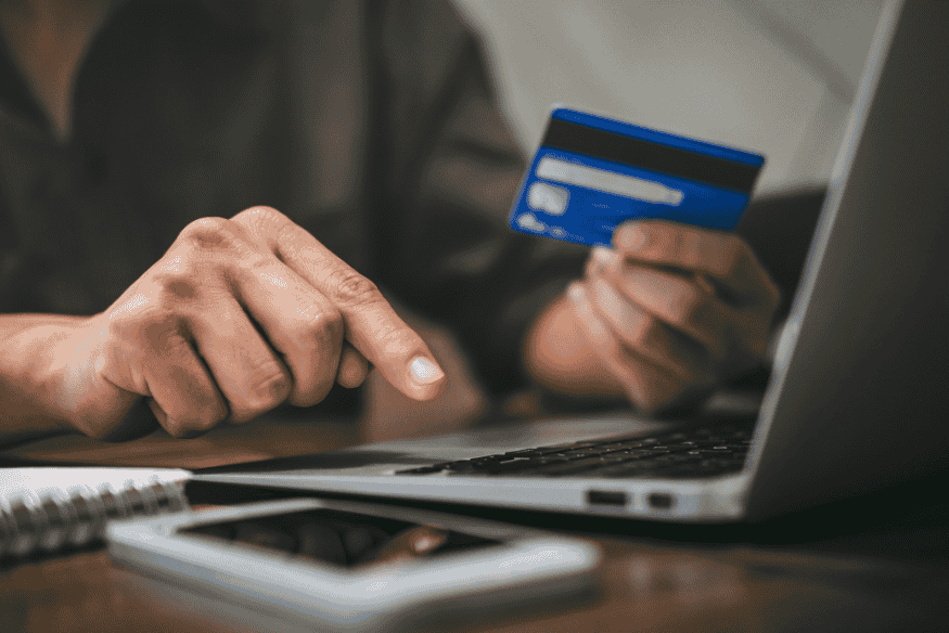 Persona pagando una compra online con tarjeta de crédito desde una laptop