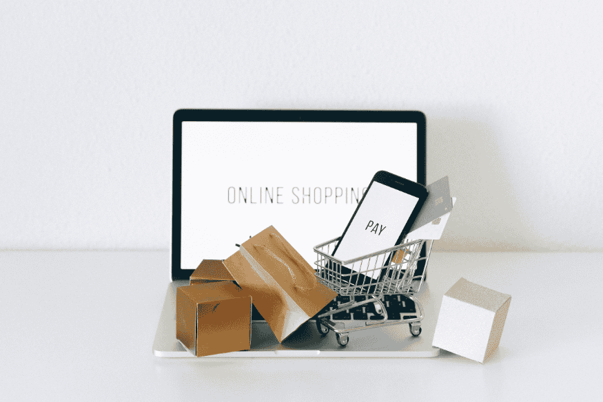 Compras online desde una laptop con carrito y paquetes como ejemplo de compra digital segura