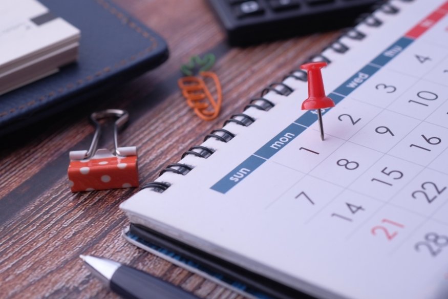 Calendario de mesa con chincheta roja señalando el primer día del mes.