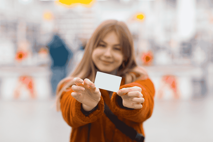 Mujer sonriente mostrando su nueva tarjeta de crédito